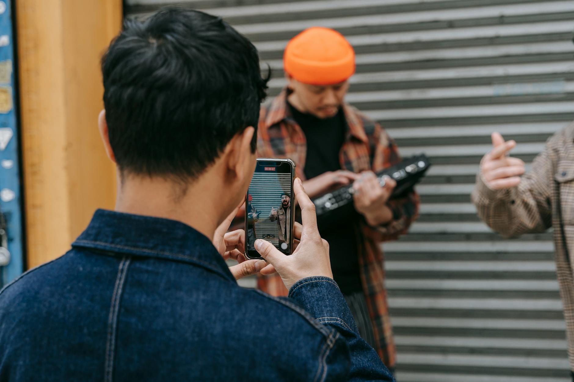 musician filming smartphone city street (Photo: Anna Pou / Pexels)
