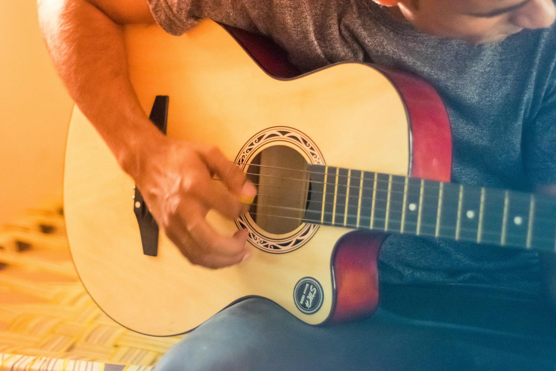musician acoustic guitar warm light (Photo: Zain Ali / Pexels)