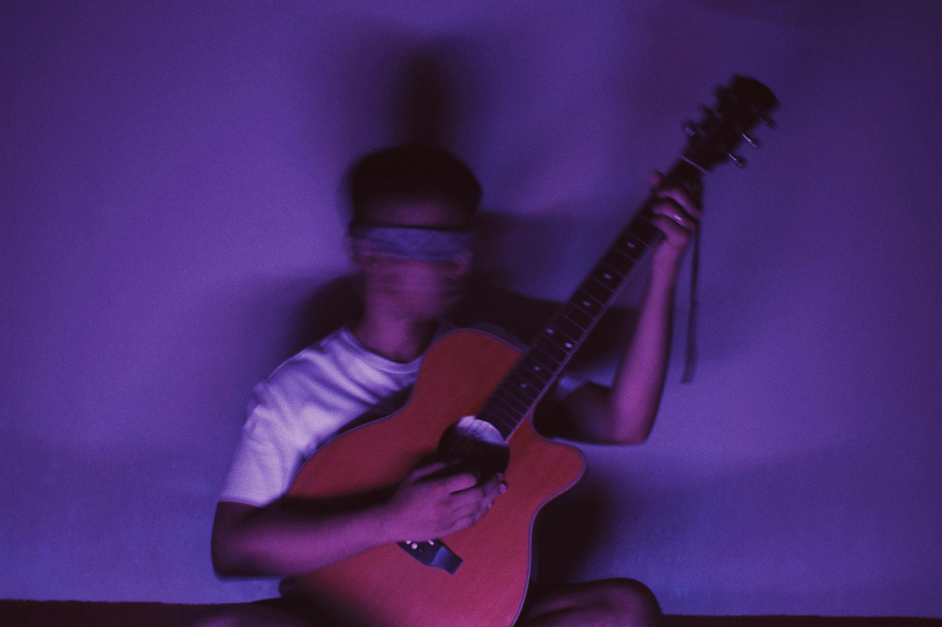 tired musician guitar dark (Photo: Nothing Ahead / Pexels)