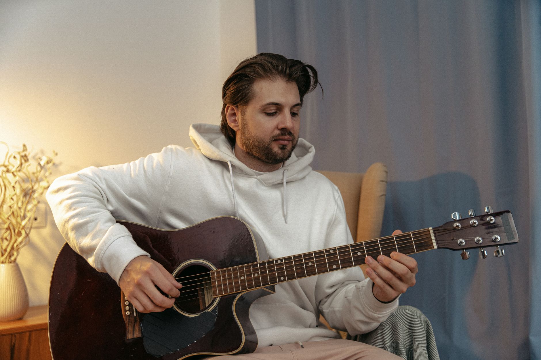 musician acoustic guitar warm light (Photo: SHVETS production / Pexels)