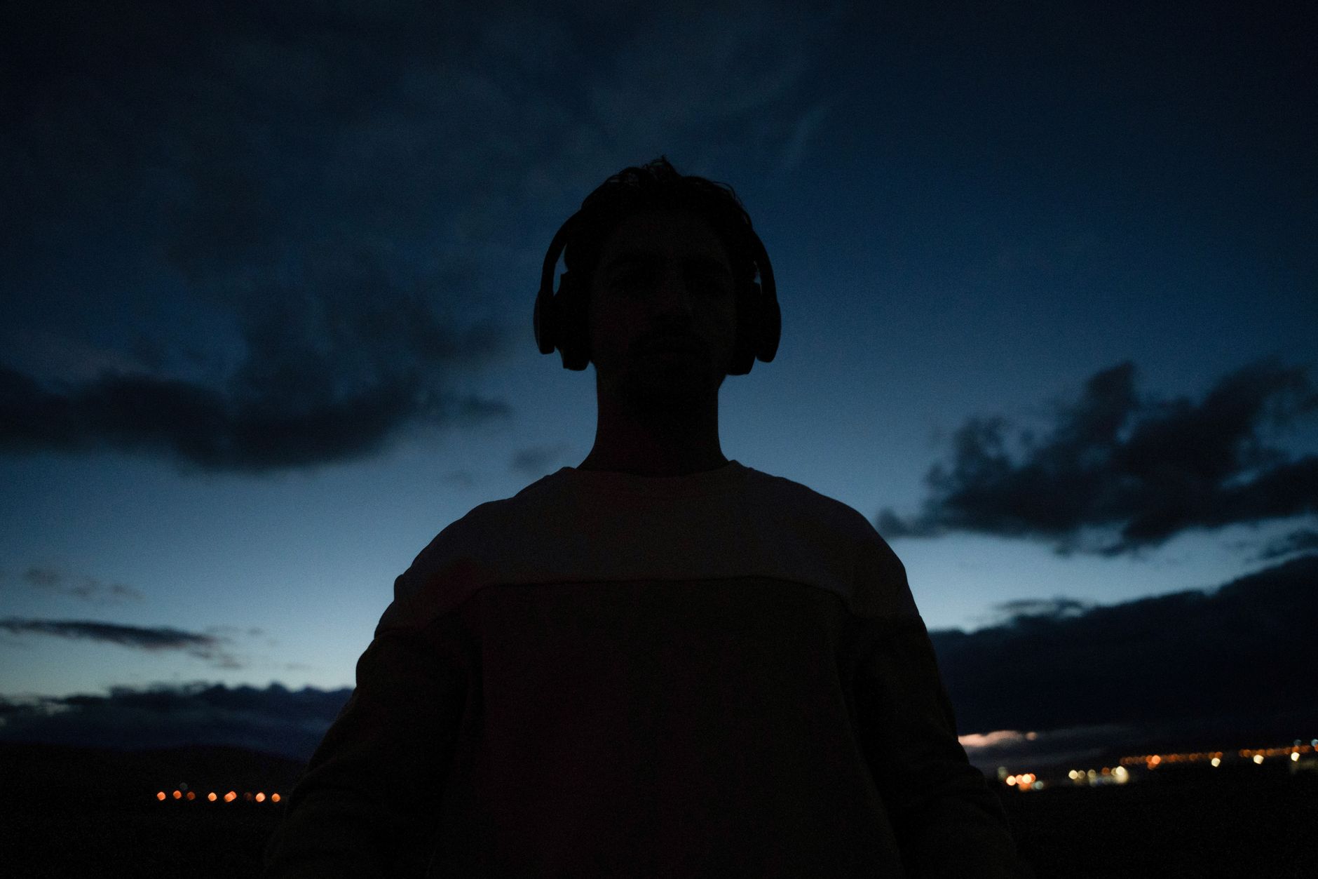 person listening headphones night (Photo: Ahmed Sadeq / Pexels)