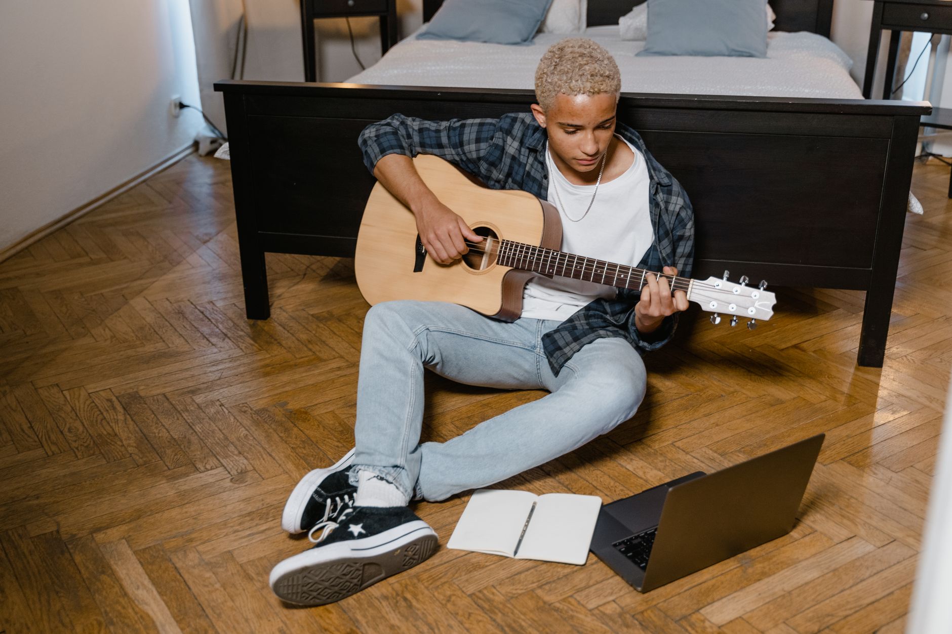 songwriter with notebook guitar (Photo: MART PRODUCTION / Pexels)