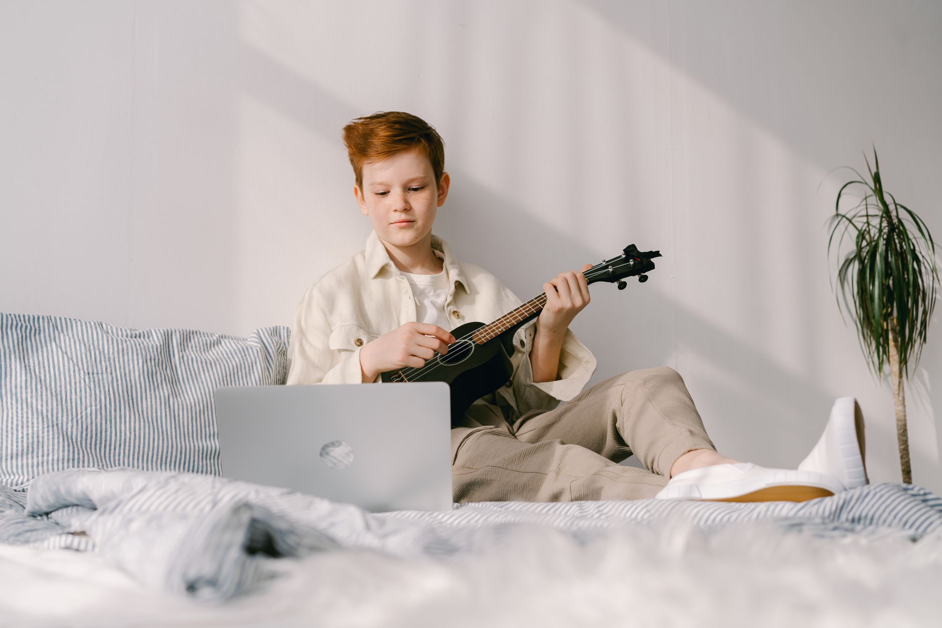 guitar and laptop warm light (Photo: Mikhail Nilov / Pexels)