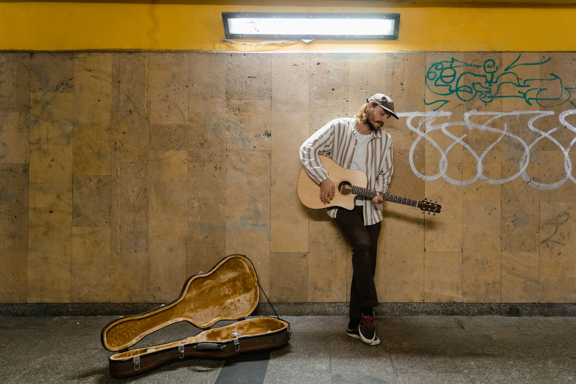 musician carrying guitar case (Photo: MART  PRODUCTION / Pexels)