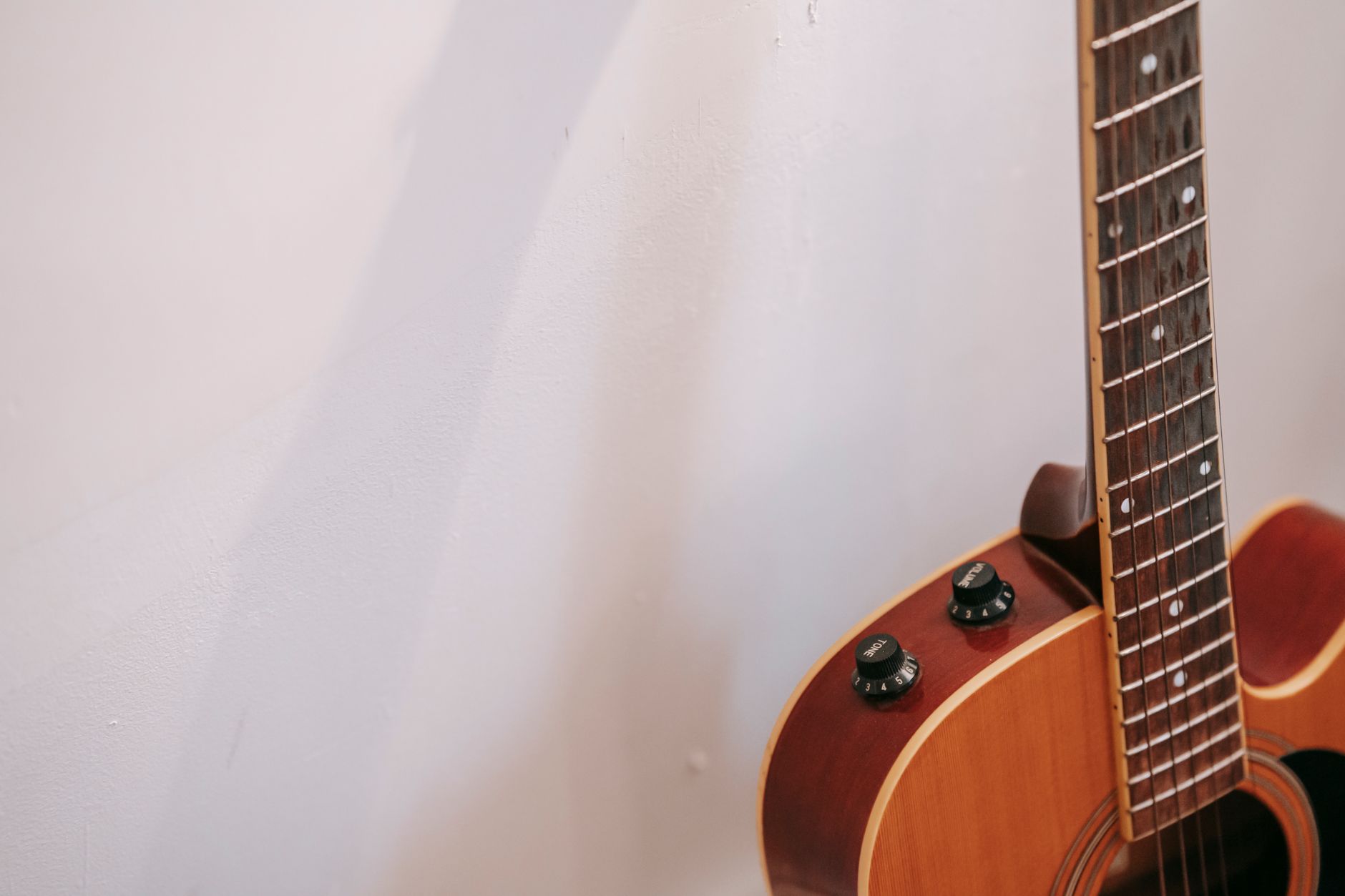acoustic guitar leaning wall (Photo: Charlotte May / Pexels)
