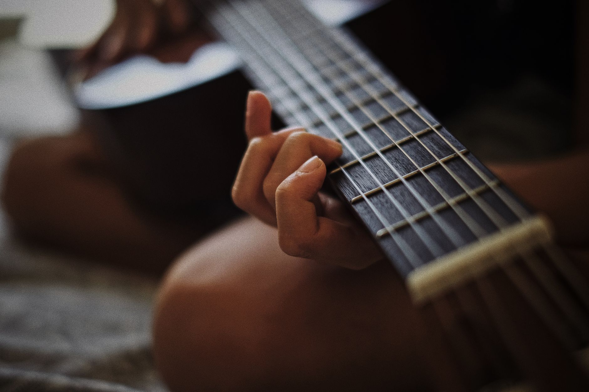musician picking up guitar (Photo: Alfredo Marco Pradil / Pexels)