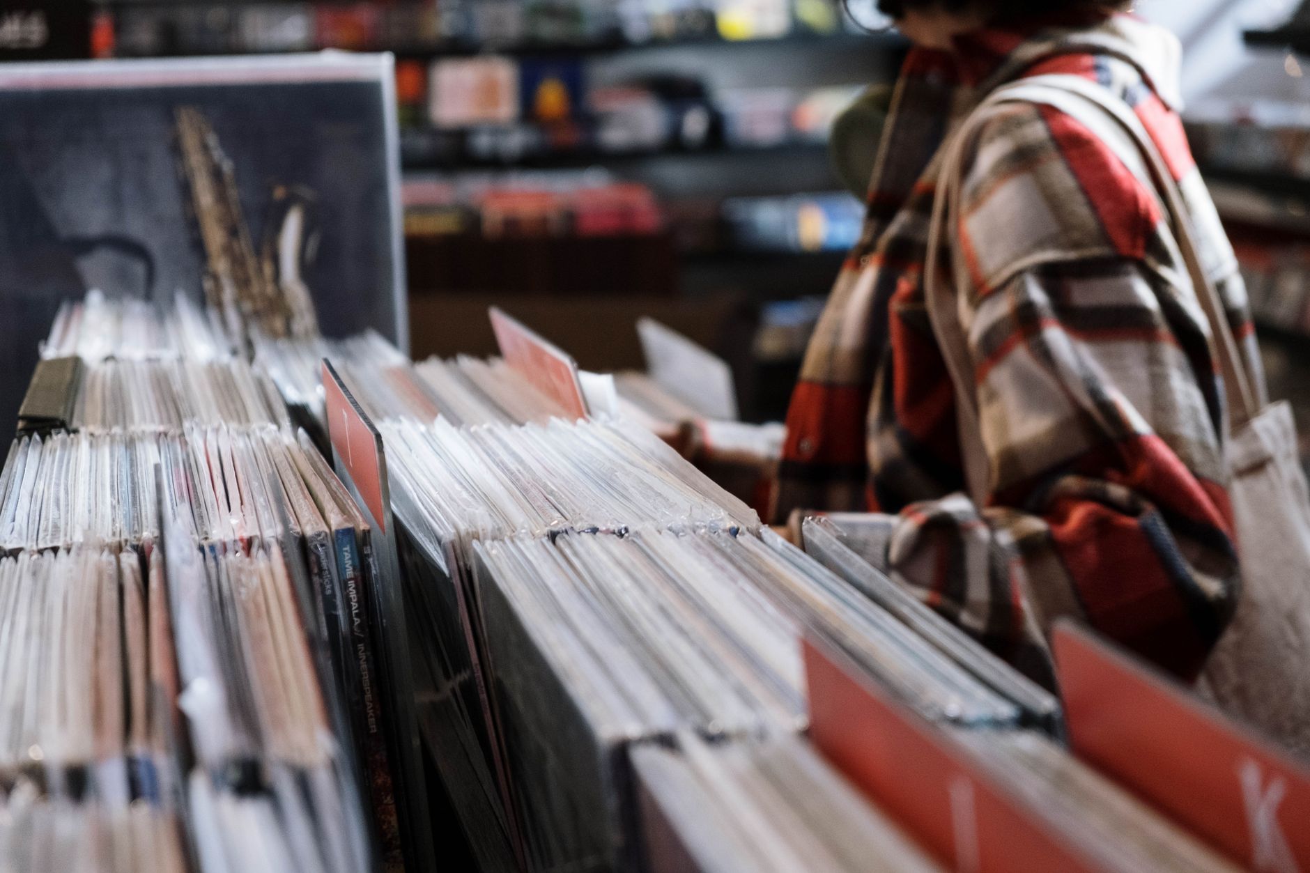 person browsing vinyl records (Photo: cottonbro studio / Pexels)
